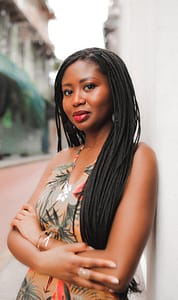 Photo of author standing with arms crossed against a building.
